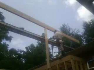 Carpenter setting a ridge beam over a new addition frame — Ice Dam Removal by Roofing Brothers in Nine Mile Falls