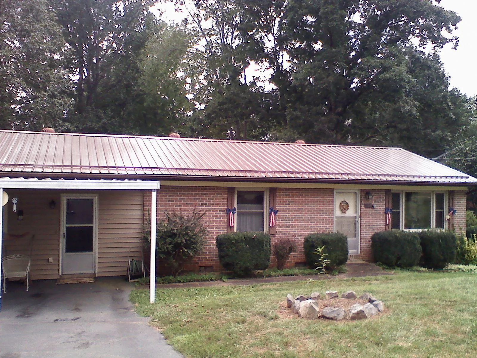 Bronze metal roof and carport on a brick ranch home — Roof Repair work by our crew in Nine Mile Falls
